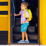 small boy boarding a school bus