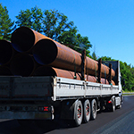 Semi truck carrying pipe on the highway